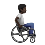 Osoba na ručním invalidním vozíku otočená doprava: tmavý odstín pleti pro Apple iOS 18.4