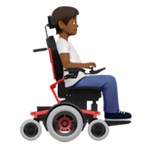 Osoba na motorovém invalidním vozíku otočená doprava: Středně tmavý odstín pleti pro Apple iOS 18.4